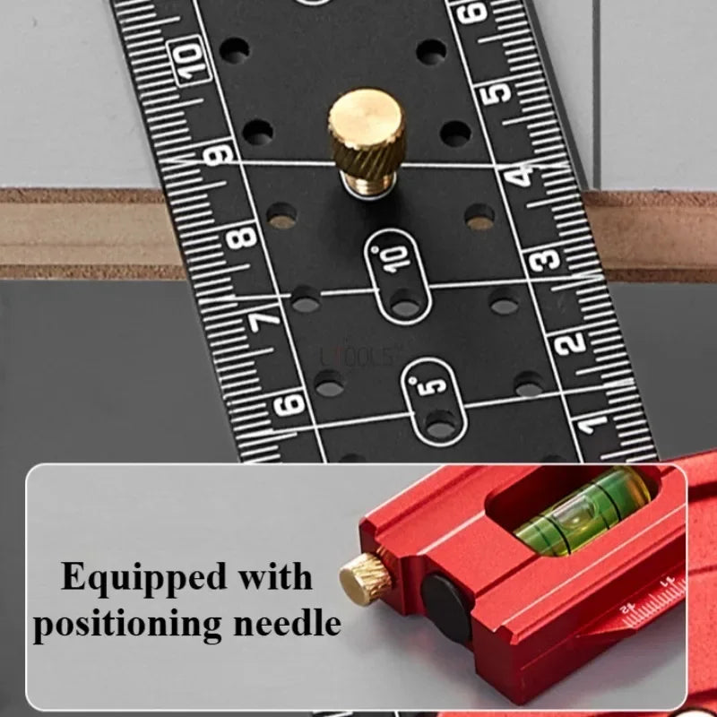A close-up of a black precision measuring ruler with a brass positioning needle and a red tool.