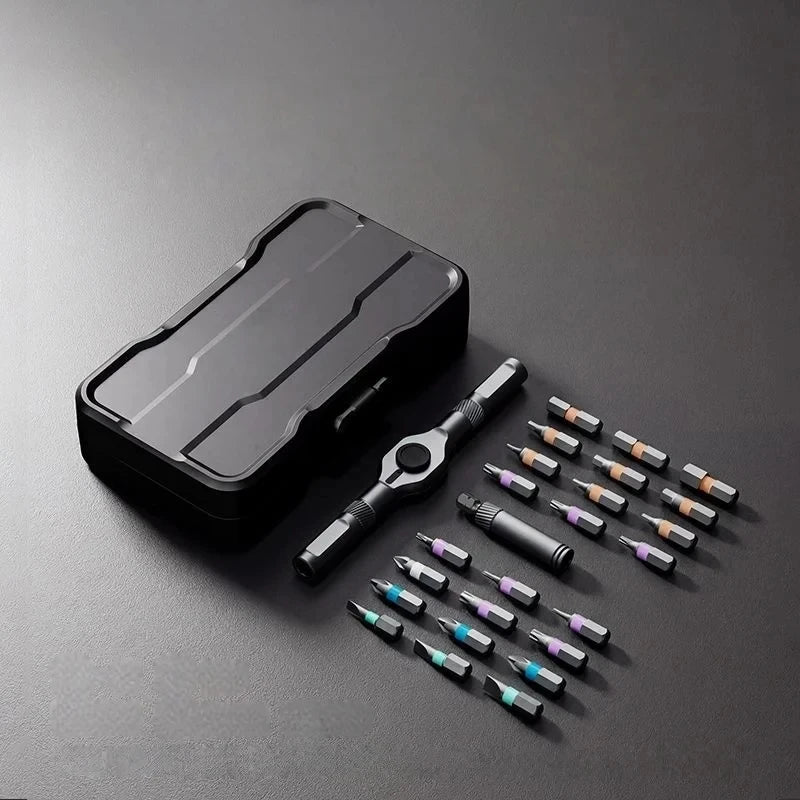 A black ratchet screwdriver set with various bits and a storage case is displayed on a dark gray surface.