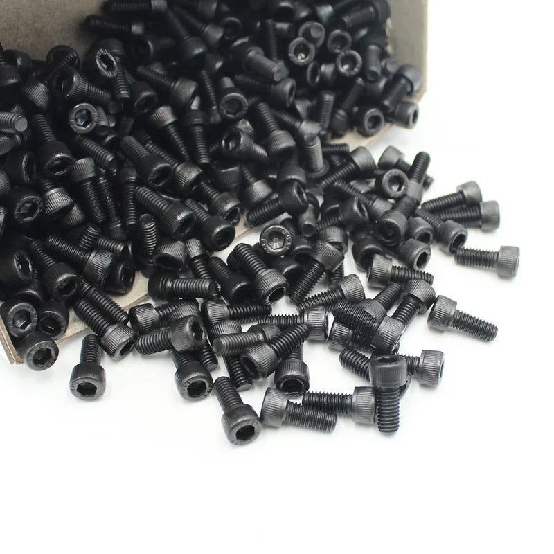 A pile of small black precision hex socket head cap screws and nuts.