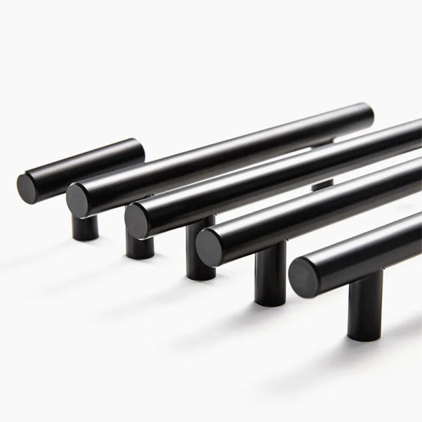A set of black stainless steel kitchen door pull handles arranged diagonally.