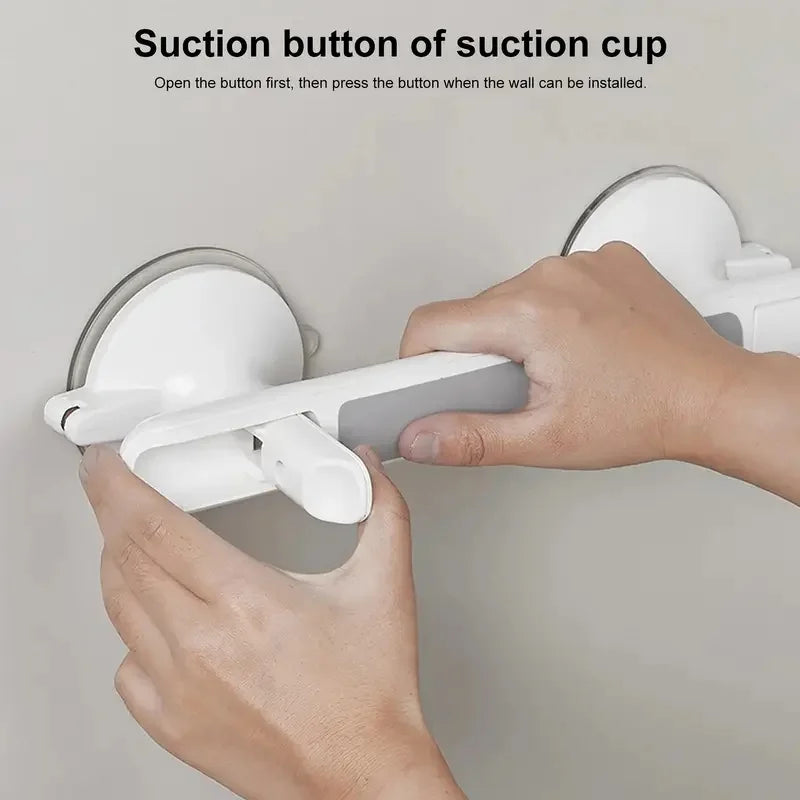 A hand is installing a white suction cup grab bar onto a wall, demonstrating the suction button operation.