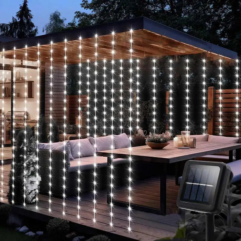 Warm white LED curtain lights illuminating a wooden deck and outdoor living area.