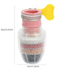 رأس دش فلتر ماء بلاستيكي شفاف بخرطوم وردي ومقبض أصفر، يظهر وسائط فلترة ملونة مختلفة بالداخل.