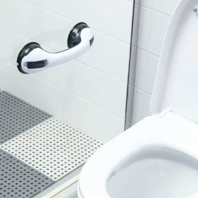 A white shower grab bar and handrail mounted on a tiled wall next to a toilet.