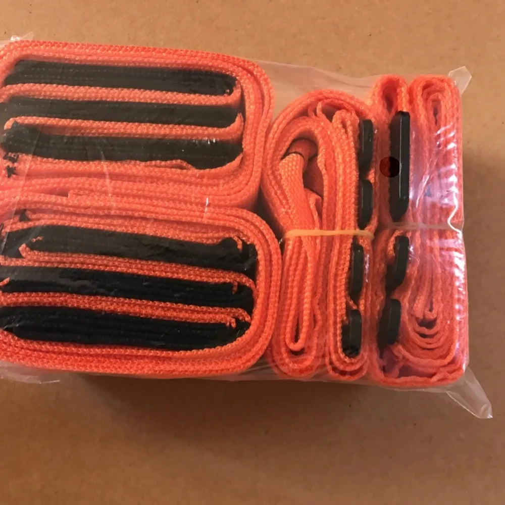 A clear plastic package containing several orange and black heavy duty furniture moving straps.
