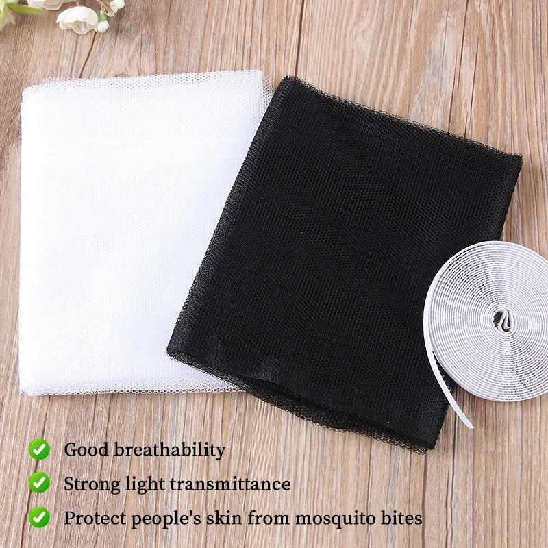 Black self-adhesive fly mosquito window net placed next to a white cloth on a wooden surface.