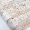 Close-up of a roll of retro wood grain self-adhesive wall stickers on a wooden surface.