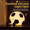 A yellow silicone football night light illuminating a soccer ball shape on a dark surface.