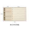 A rectangular beige jewelry storage tray with three compartments and a ribbed design.