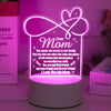 A glowing pink heart-shaped sign light featuring a message to mom on a white base.
