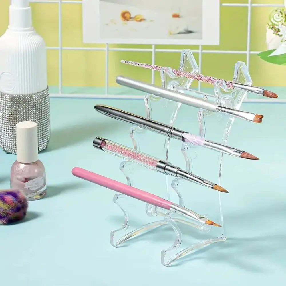 A clear acrylic organizer holds several silver and pink ballpoint pens on a light blue surface.