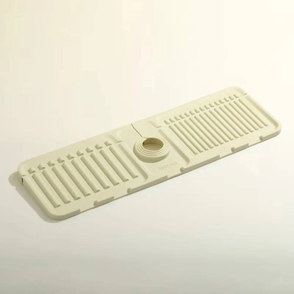 A beige silicone sink drain mat with ribbed texture and a central drain hole.