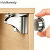 A hand is opening a wooden cabinet door to show an invisible magnetic child safety lock mechanism.