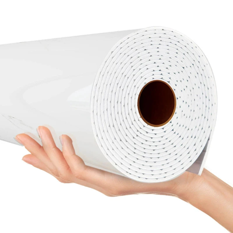 Une main tient un rouleau d'autocollants imitation marbre blanc pour murs.