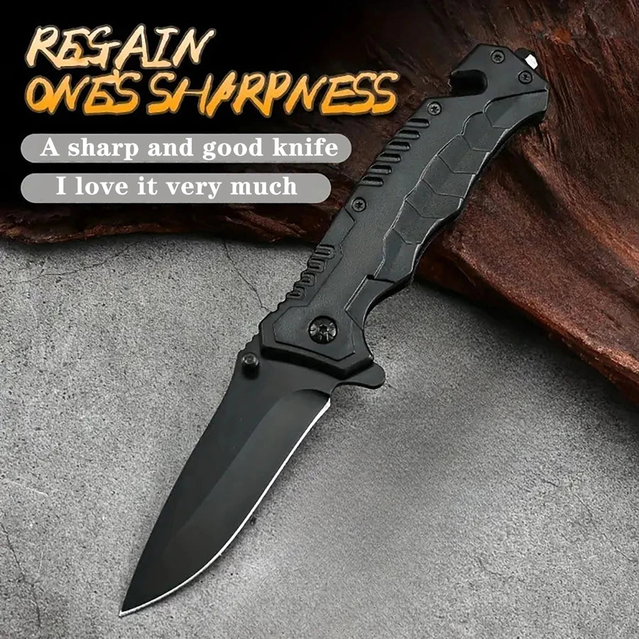 A black multi-functional camping survival knife is displayed on a gray surface.