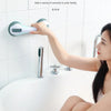A woman is using a vacuum sucker safety armrest attached to a shower faucet and handrail.
