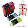 A set of colorful adjustable luggage straps with password locks and a silver rolling suitcase.