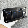Un panneau noir avec trois cellules solaires et un chargeur 5V 4.8A est tenu dans une main sur un fond de tissu gris.