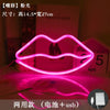 A pink neon heart lip light decoration is displayed on a surface, with a box showing the month April.