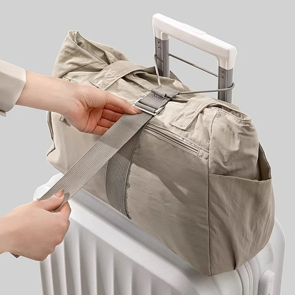 A hand is adjusting an adjustable quick-release luggage strap on a beige canvas backpack placed on a white radiator.