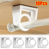 Ten pack of white 360 degree rotating adhesive curtain rod brackets mounted on a wooden surface.