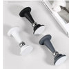 A collection of door stoppers in black, white, and silver finishes shown against a white background.