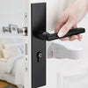 A hand is operating a black universal adhesive door latch on a white door frame for child safety.