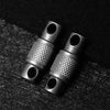 Two titanium alloy keychain key holders with textured surfaces resting on a dark background.