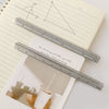 A close-up of a multicolor aluminum triangular ruler used for crafting, showing various measurements and angles.
