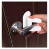 A hand is operating a white universal adhesive door latch on a brown wooden door.