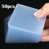 A hand holds a stack of 50 clear, translucent double-sided nano adhesive pads.