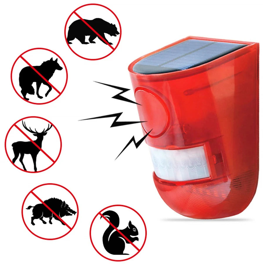 A red solar infrared motion sensor security alarm device with a solar panel on top, surrounded by silhouettes of various anim