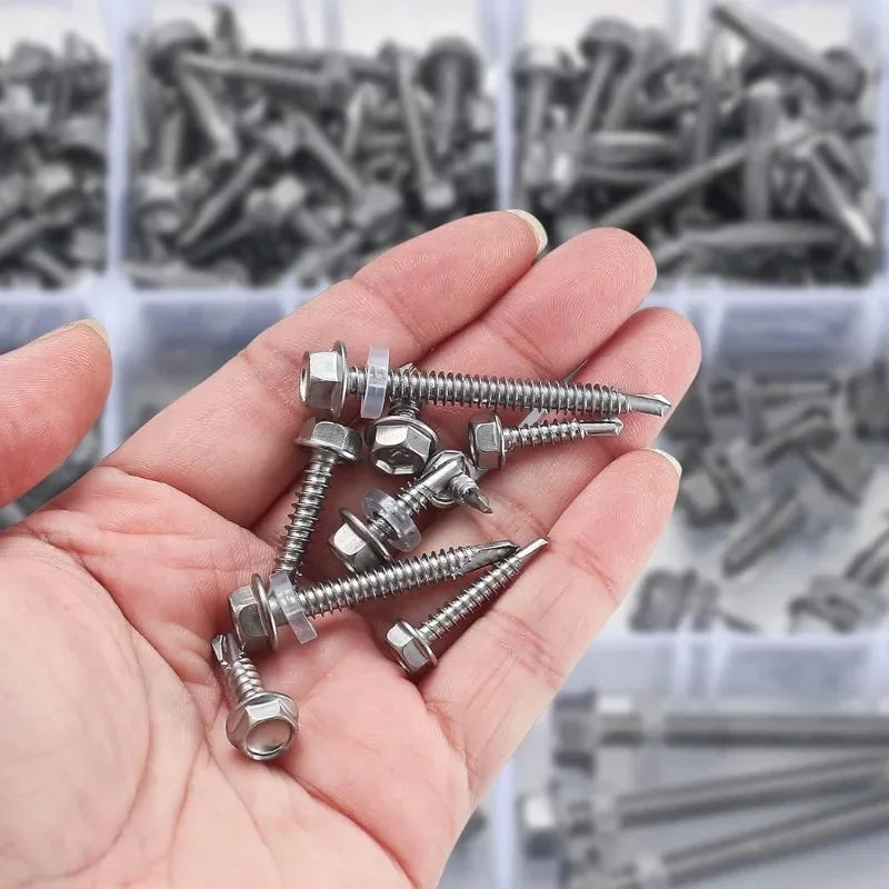 A hand holds a small pile of stainless steel self-drilling screws for roofing and DIY projects.