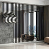 Modernes Interieur mit schwariger vertikaler Lamellenwand und gebogener metallischer Akzentplatte.
