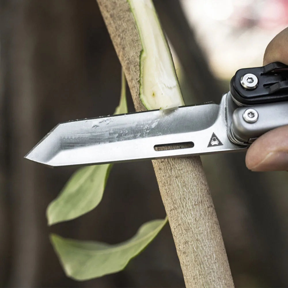 A hand holds a silver pocket knife slicing through a plant stem.