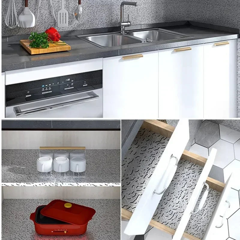 Küchenaufbau mit Edelstahlspüle, dunker Arbeitsplatte und weißen Schränken mit Aluminiumfolien-Sticker und einem O