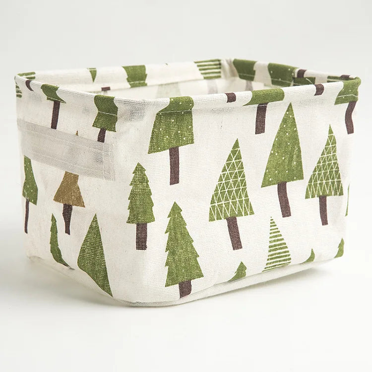 A light linen storage basket with a green and brown pine tree pattern.