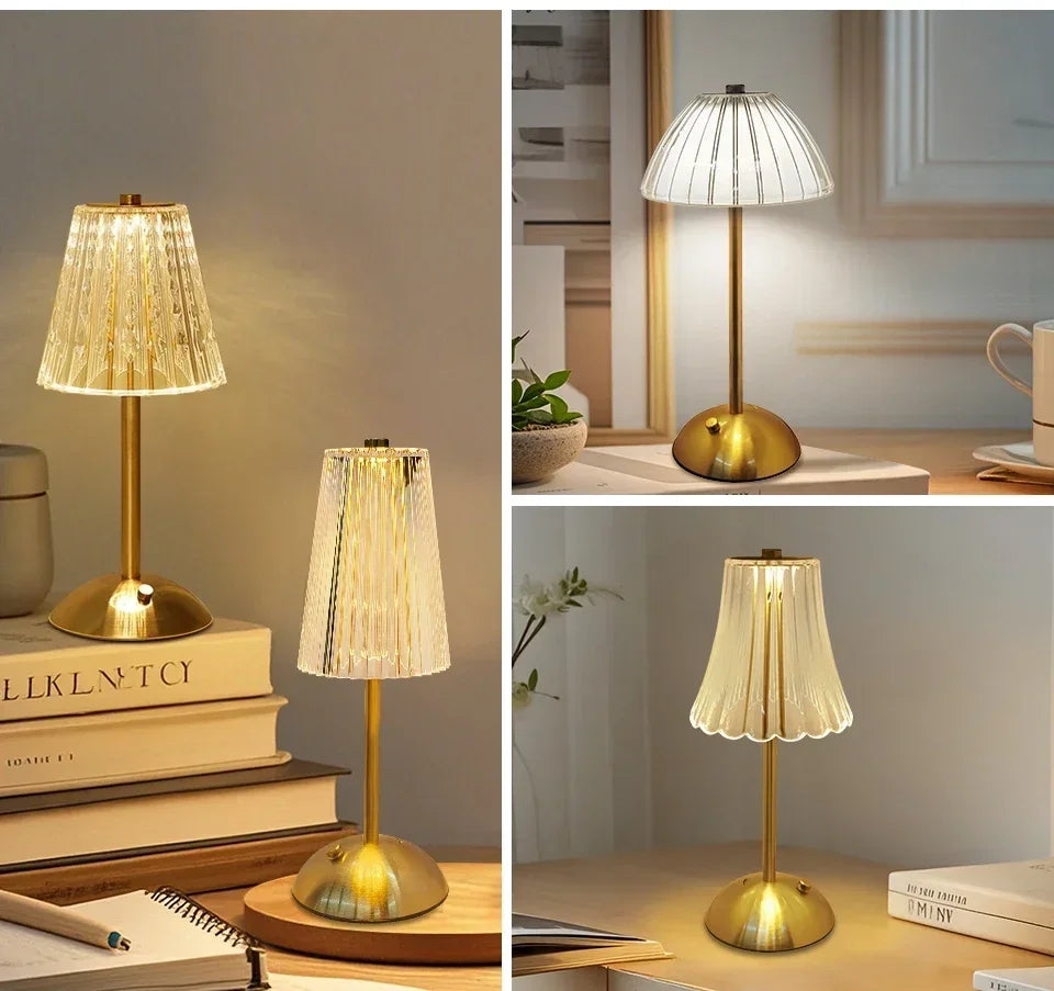 A brass desktop reading lamp with a textured glass shade illuminates a book on a wooden surface.