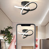 A hand holds a smartphone displaying a modern LED ceiling light fixture with an abstract design.