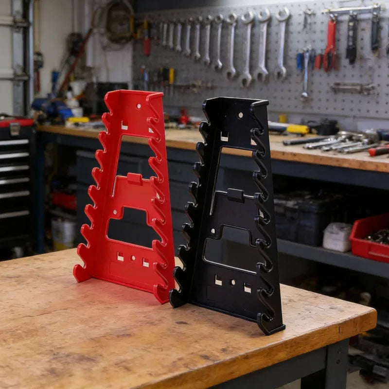 A red plastic wrench organizer rack and a black wrench organizer rack resting on a wooden workbench.