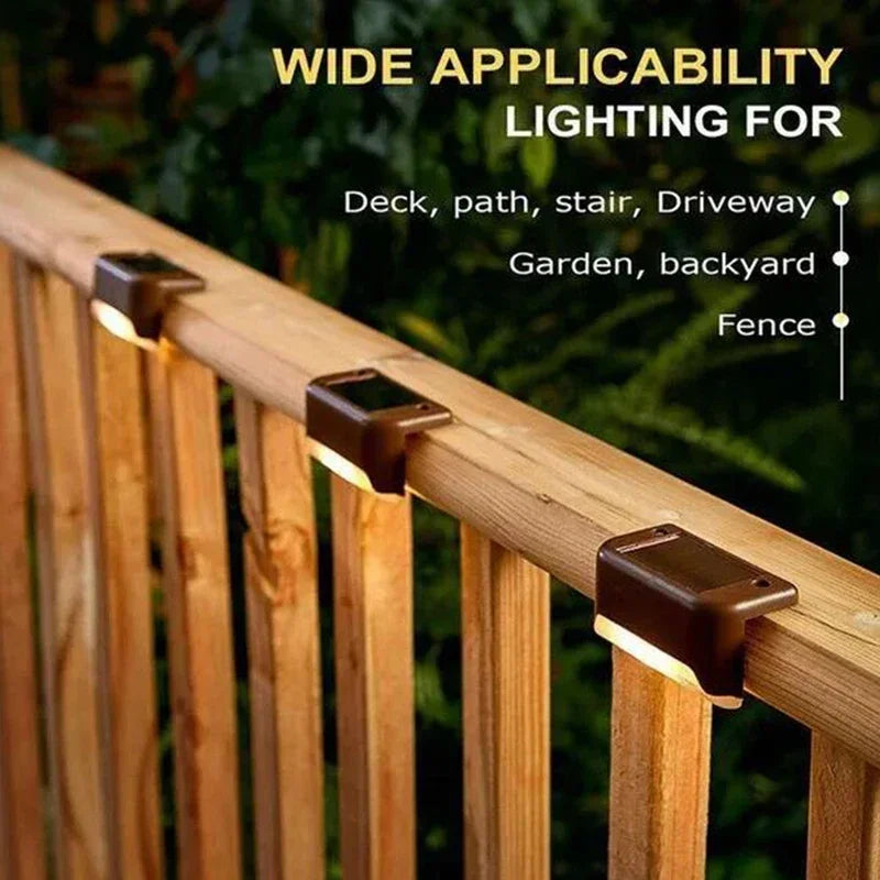 Close-up of a solar LED step light mounted on a wooden fence railing for outdoor lighting.