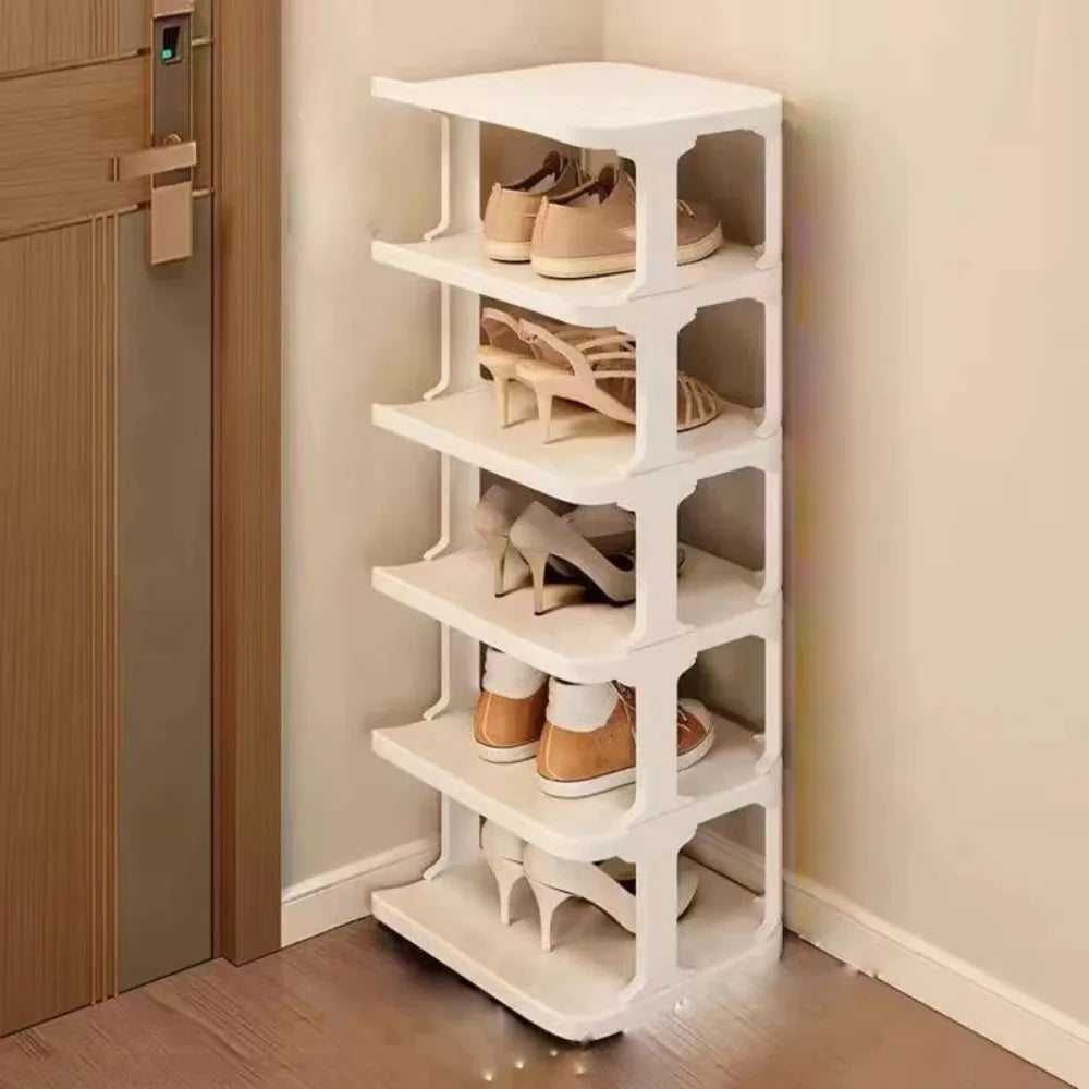 A white stackable vertical shoe rack organizer with multiple tiers is shown next to a wooden door.