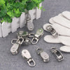 Stainless steel wire rope pulley block hardware and white knitted items displayed on a gray fabric background.