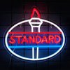 A circular neon sign displaying the word STANDARD in red and blue lettering on a dark background.
