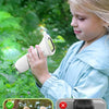 A young girl is using a pocket digital microscope to explore plants outdoors.