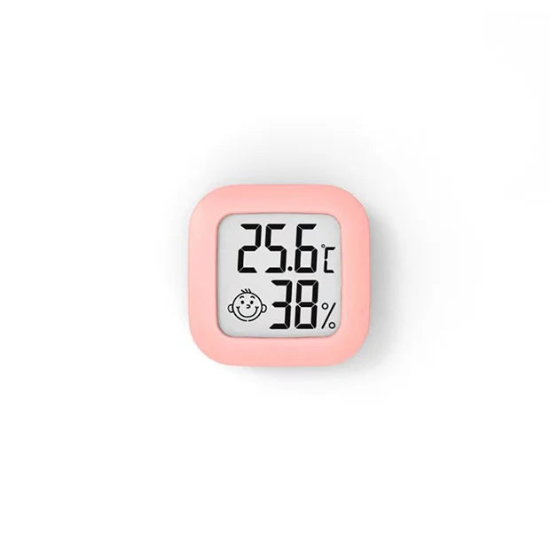 A pink compact digital thermometer displaying a temperature of 25.6°C and 38% humidity.
