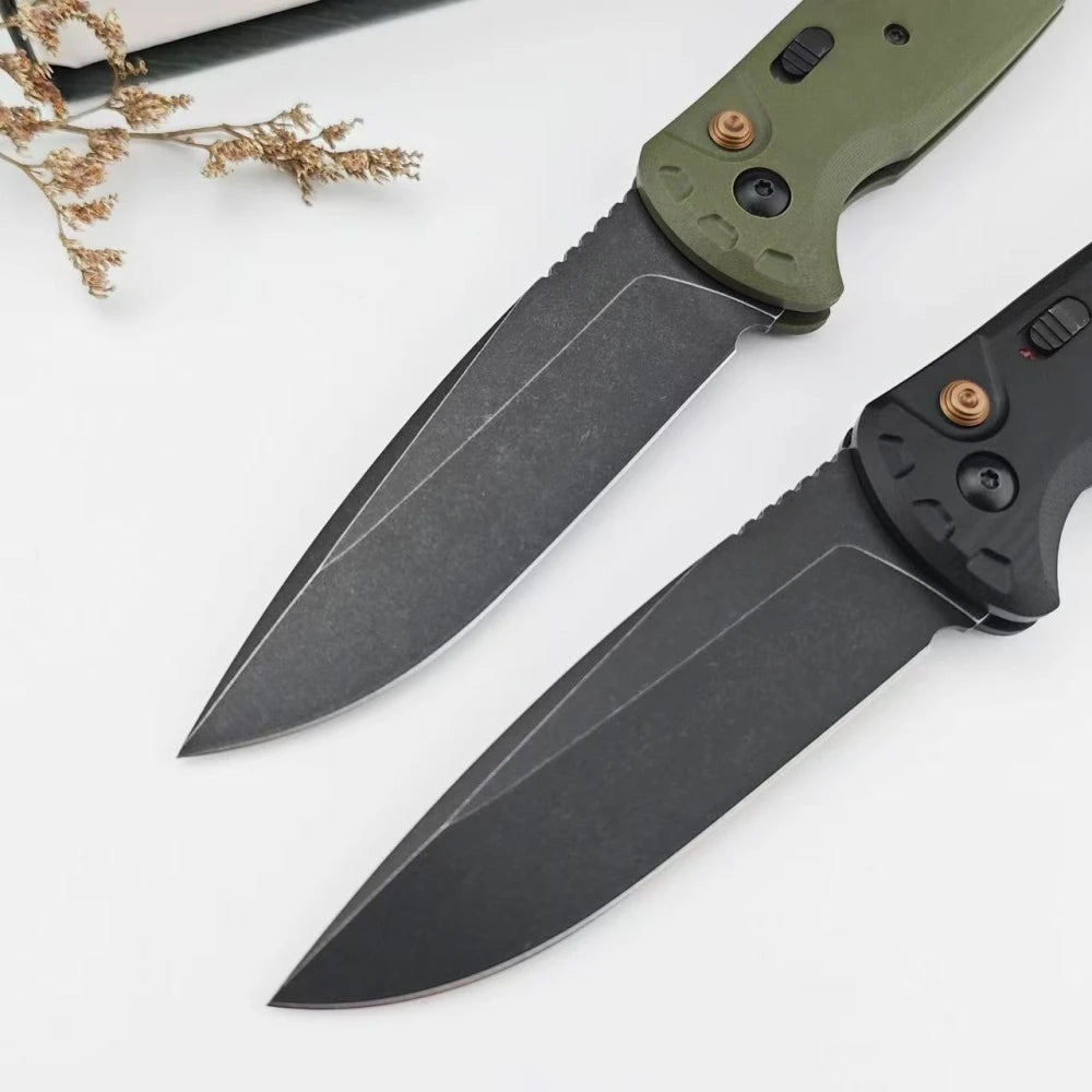 A folding utility knife with a green handle and black blade resting on a white surface.