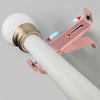 Close-up of a rose gold adjustable metal curtain rod bracket being installed onto a white pole.