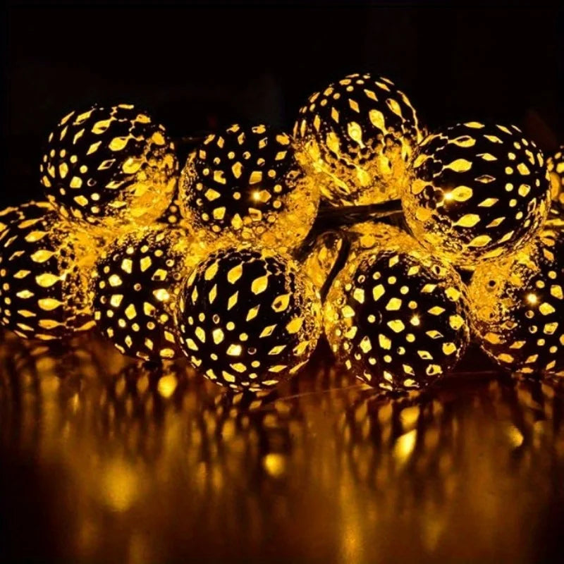 Primer plano de luces de Navidad solares LED amarillas brillantes morocanas reflejándose en una superficie oscura.