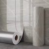 Roll of marble imitation self-adhesive wall stickers against a light gray textured wall.